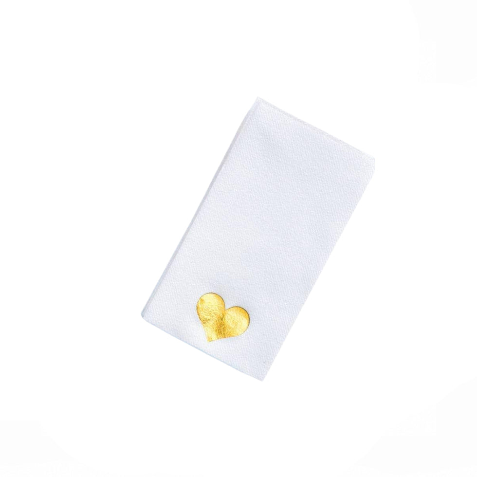 A white rectangular fabric item, likely a napkin or small towel, featuring a small, textured gold heart emblem near the bottom left corner, set against a solid white background.