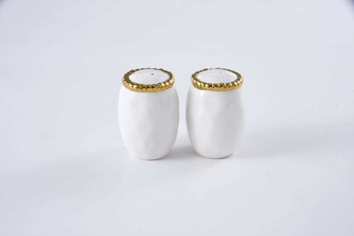 Two white ceramic salt and pepper shakers with gold rims on a light gray background