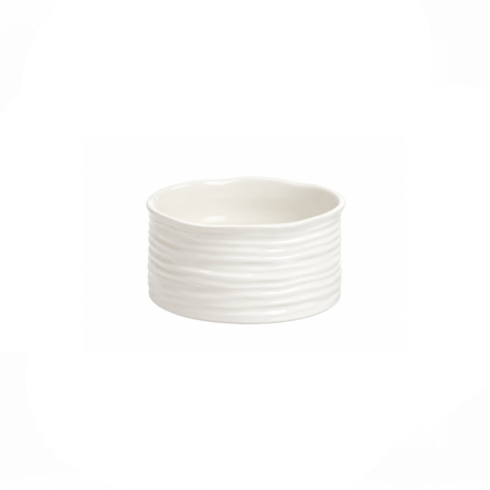 A small white ceramic bowl with a fluted, ribbed exterior and a scalloped rim, shown against a plain white background.