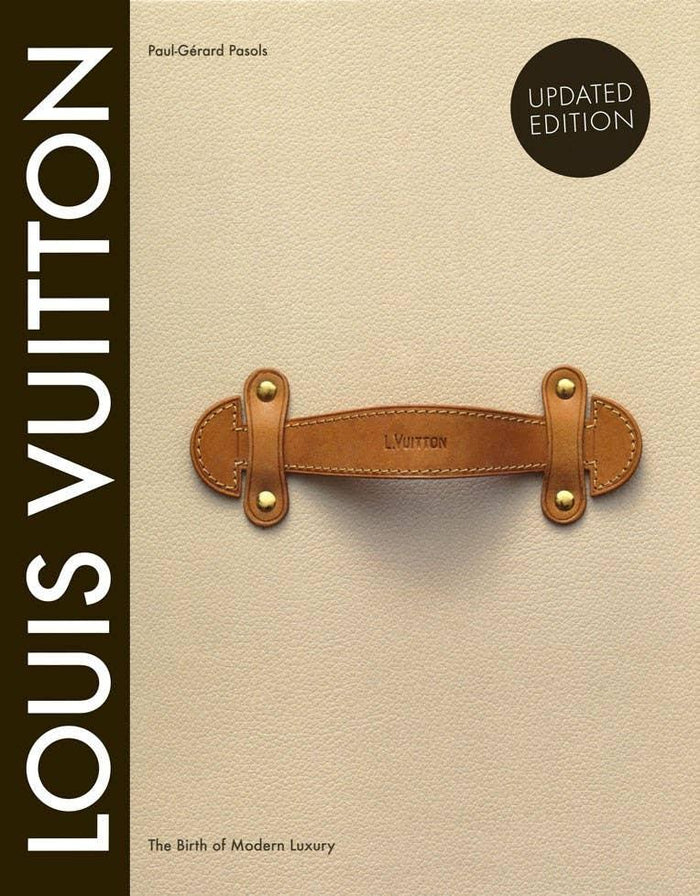 Book cover of 'Louis Vuitton: The Birth of Modern Luxury' with a leather handle on a beige background Luxury Fashion Archive