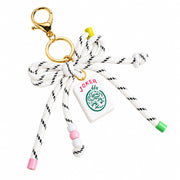 A novelty keychain or bag charm featuring a white braided rope tied in a bow, a gold-tone lobster clasp and ring, a white joker tile charm with green and red details, and colorful bead accents on a white background.