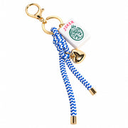 A novelty keychain featuring a blue and white chevron-patterned rope, a gold-tone lobster clasp, a gold-tone heart charm, and a white tag with the word 'JOKER' and a green circular emblem.