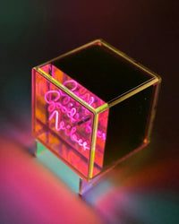 Neon cube with 'Good Vibes' text on a dark background
